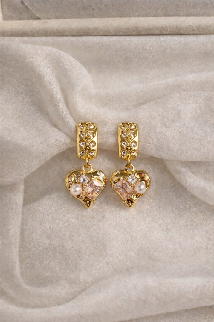 Gold heart-shaped earrings on white fabric (1)